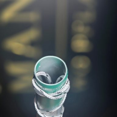 Eingekreistes silbernes Ringdesign auf einem spiegelnden Untergrund.